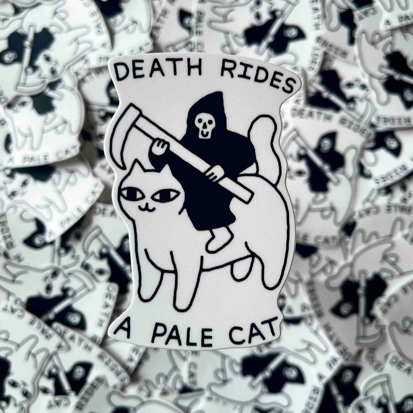 A die-cut sticker featuring a black and white illustration of the Grim Reaper riding a pale cat, with the text 'DEATH RIDES A PALE CAT' on a white background surrounded by a pile of identical stickers.